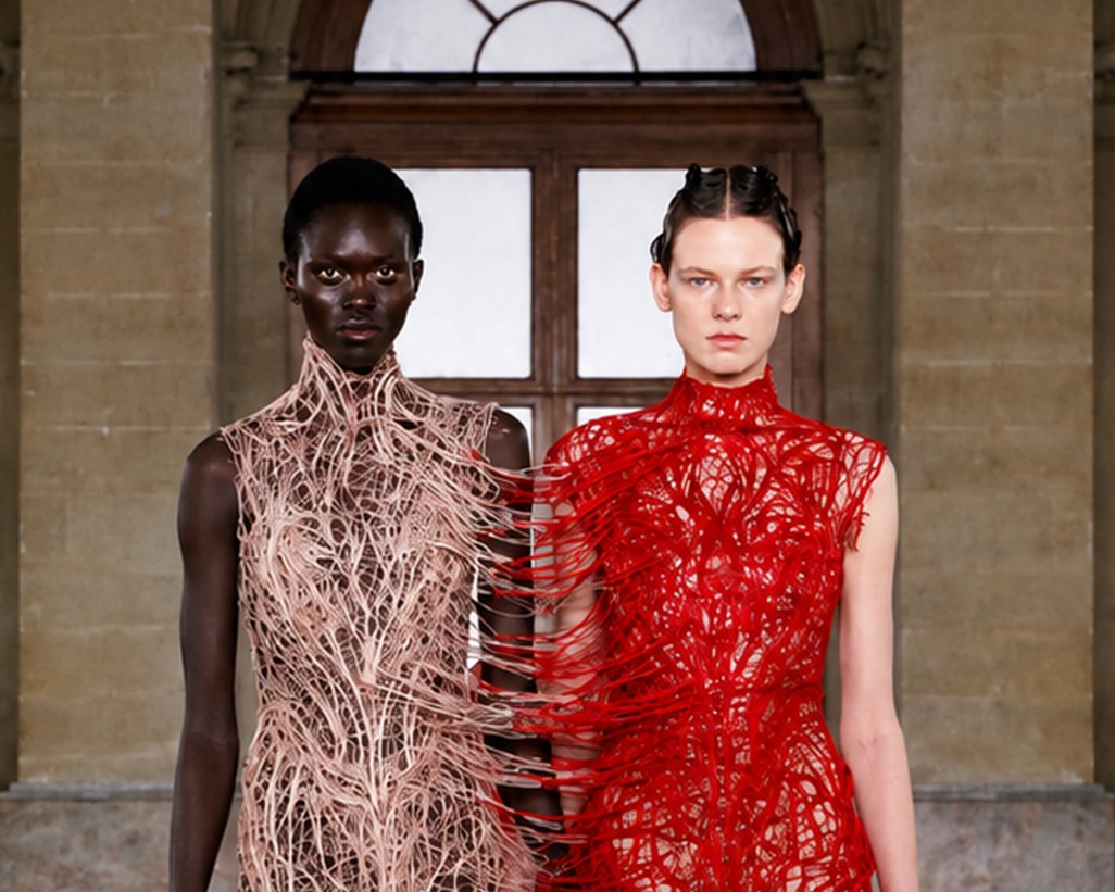 Two figures in Gaurav Gupta designs joined by red and beige threads